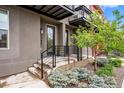 Modern townhome entrance with landscaping, gray exterior and a black door and iron railing at 3480 E 31St Ave, Denver, CO 80205
