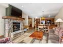 Open-concept living area with stone fireplace, TV, and kitchen view, perfect for modern living at 50 Mountain Thunder Dr # 1212, Breckenridge, CO 80424