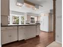 Bright kitchen features an island, wood floors, light-colored cabinets, and large windows offering natural light at 150 Soda Creek Rd, Evergreen, CO 80439