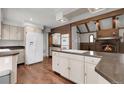 Spacious kitchen with stainless steel appliances, an island cooktop, and a brick wall fireplace in the background at 150 Soda Creek Rd, Evergreen, CO 80439
