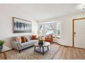 Bright living room showcasing a bay window, wood floors, and stylish seating arrangement at 9652 Cove Creek Dr, Highlands Ranch, CO 80129