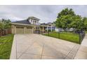 Inviting two-story home featuring a well-manicured lawn, a charming balcony, and a spacious two car attached garage at 940 Kearney St, Denver, CO 80220