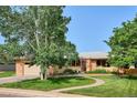 Inviting home featuring mature landscaping, a brick walkway, and a well-manicured lawn at 2300 Crabtree Dr, Centennial, CO 80121