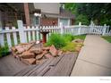 Charming front yard with a birdbath, garden, stepping stones, and a white picket fence at 9864 Carmel Ct, Lone Tree, CO 80124