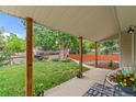 Cozy front porch with wooden support beams and an inviting view of the landscaped yard at 936 Utica St, Denver, CO 80204