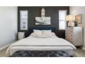 Serene bedroom features a dark accent wall, soft lighting, and a plush, inviting bed at 9612 Reunion Pkwy, Commerce City, CO 80022