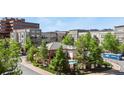 A bird's eye view shows a community pool and clubhouse surrounded by well-maintained landscaping and multi-story condo buildings at 5677 S Park Pl # 303, Englewood, CO 80111
