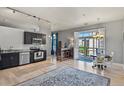 Open-concept living space with modern kitchen, hardwood floors, dining area, and a walk out to the balcony at 5677 S Park Pl # 303, Englewood, CO 80111