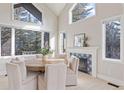 Bright dining area with large windows, a cozy fireplace, and seating for six at 31699 Southern Hills Pl, Evergreen, CO 80439