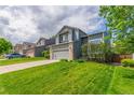 Two-story home featuring a two-car garage, a basketball hoop, and a well-maintained lawn on a suburban street at 4935 Apollo Bay Dr, Highlands Ranch, CO 80130