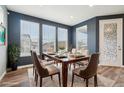 Bright dining room with large windows, modern table set and stylish decor at 5128 Preserve Pl, Firestone, CO 80504