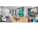 Open-concept living space with hardwood floors, modern decor, and seamless flow to dining area at 1852 S Forest St, Denver, CO 80222