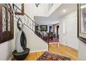 Inviting foyer with hardwood floors, elegant staircase, and unique decorative water feature at 10889 Alcott Ct, Denver, CO 80234