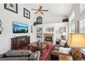 Bright living room with a brick fireplace, built-in shelves, and comfortable leather seating at 10889 Alcott Ct, Denver, CO 80234