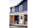Inviting exterior featuring a blue facade, brick accents, and a welcoming front porch with visible house number at 3100 S Holly Pl, Denver, CO 80222