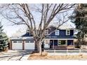 Charming two-story home featuring a two-car garage, lovely brick accents, and a quaint white picket fence at 3100 S Holly Pl, Denver, CO 80222
