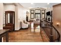 Inviting foyer with hardwood floors, staircase, sitting area, and large windows offering an abundance of natural light at 8294 Wild Timber Dr, Franktown, CO 80116