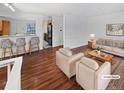 Bright living room with hardwood floors, neutral paint, and comfortable seating arrangement, virtually staged at 1045 Mobile St, Aurora, CO 80011