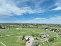 A picturesque aerial view of this home showcasing the large green field and a perimeter fence at 595 W Oak Hill Ln, Castle Rock, CO 80108