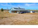 View of the horse barn featuring a metal roof, stalls, and room for parking farm equipment at 595 W Oak Hill Ln, Castle Rock, CO 80108