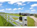 Idyllic horse property with white fencing, green pastures, and a glimpse of the beautiful home in the distance at 595 W Oak Hill Ln, Castle Rock, CO 80108