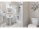 Updated bathroom with tiled shower and tub, pedestal sink, and modern fixtures at 328 E Dakota Ave, Denver, CO 80209