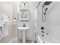Bathroom featuring a pedestal sink, modern fixtures, and tiled shower and tub at 328 E Dakota Ave, Denver, CO 80209
