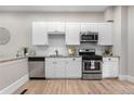 Contemporary kitchen featuring stainless steel appliances, white cabinets, and granite countertops at 328 E Dakota Ave, Denver, CO 80209