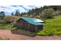 Rustic outbuilding with a green metal roof and wood siding at 15947 S Perry Park Rd, Palmer Lake, CO 80133