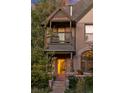 Close-up of a brick house featuring a balcony and a inviting pink front door at 2358 N Ogden St # B, Denver, CO 80205