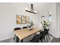 The dining room offers natural light and a modern chandelier above a wooden table with seating at 4286 S Eldridge St # 202, Morrison, CO 80465