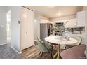 Cozy dining area featuring a modern round table, stylish chairs, and a view of the updated kitchen at 720 S Clinton St # 2D, Denver, CO 80247