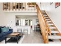 Bright living space features a loft, open staircase, and view into the updated kitchen at 3026 W Prentice Ave # H, Littleton, CO 80123