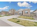 Charming single-Gathering home with brick facade, well-manicured lawn, and a two-car garage on a sunny day at 7051 S White Crow Way, Aurora, CO 80016