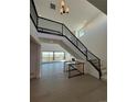 Bright, open foyer with a staircase, iron railing, hardwood floors, and views of the outdoor deck at 6036 Riesberg Ln, Castle Rock, CO 80104