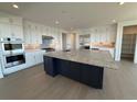 Gourmet kitchen featuring a large island with granite countertops, stainless steel appliances, and ample cabinetry at 6036 Riesberg Ln, Castle Rock, CO 80104