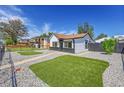 Charming home featuring stylish black and white exterior with modern rock landscaping and synthetic turf at 3064 S Galapago St, Englewood, CO 80110
