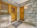 Close-up of home's stone entryway with multiple wooden doors and a small covered porch at 1453 Vine St, Denver, CO 80206