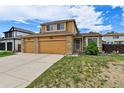 Two-story home with a three-car garage, stone accents and manicured lawn under a blue sky at 20651 E 42Nd Ave, Denver, CO 80249