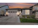 Well-maintained single-story home with stone accents, neat landscaping, and a two-car attached garage at 9055 Swan River St, Littleton, CO 80125