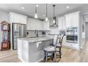 Modern kitchen featuring white cabinets, stainless steel appliances, and a granite island with bar stool seating at 9055 Swan River St, Littleton, CO 80125