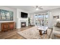 Cozy living room with a fireplace, ceiling fan, and sliding glass doors that open to a deck at 9055 Swan River St, Littleton, CO 80125
