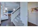Carpeted staircase with hardwood floors and living area visible nearby creates an inviting and stylish transition at 1176 Sugarloaf Ln, Erie, CO 80516