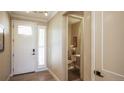 Bright entryway with powder room, wood floors, and a white door at 6922 Copper Sky Cir, Castle Pines, CO 80108
