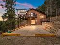 Back of house with a nice stone patio and elevated deck perfect for outdoor entertaining at 11093 Milliken Ave, Conifer, CO 80433