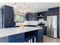 Modern kitchen with blue cabinetry, stainless steel appliances, and white countertops at 7596 Rafter Rd, Franktown, CO 80116