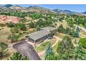 Expansive aerial view of home showcasing mature trees, large driveway, and complementary architectural details at 6227 Colorow Dr, Morrison, CO 80465