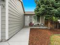 Charming single-story home featuring an inviting front porch and landscaped garden with wood chips at 17411 E Layton Dr, Aurora, CO 80015