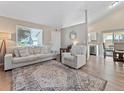 Bright living room with modern furniture, large windows, and an inviting open layout to the kitchen at 17411 E Layton Dr, Aurora, CO 80015