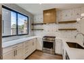 Sleek, modern kitchen with stainless steel appliances, geometric backsplash and floating wood shelves at 1937 S Columbine St, Denver, CO 80210